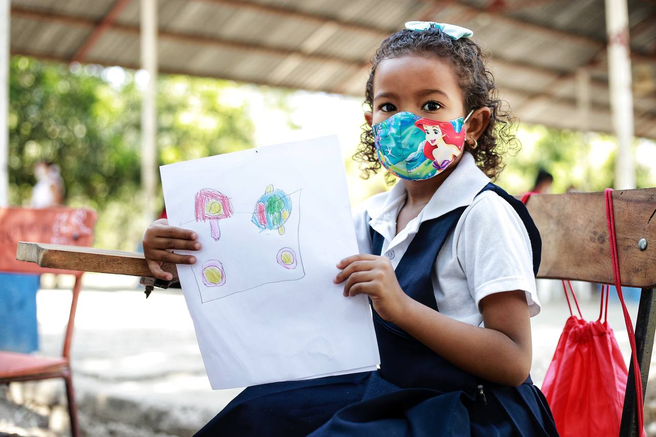 Una niña en el colegio mostrando su tarea
