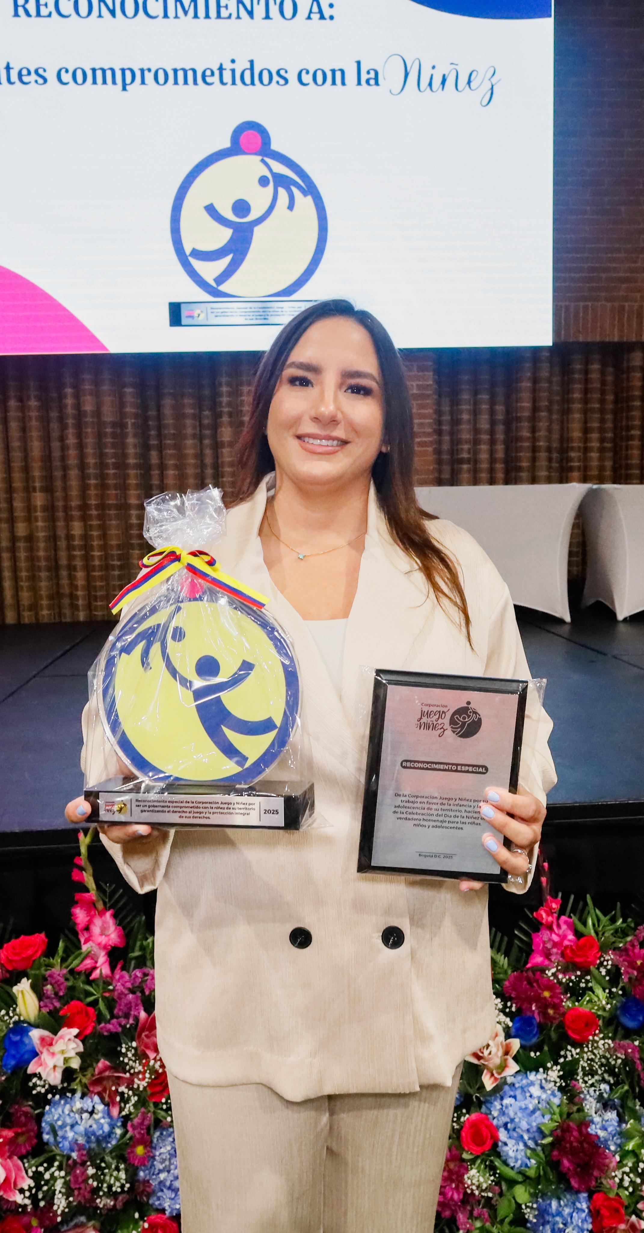 Gestora social muestra el trofeo y la placa del reconocimiento nacional