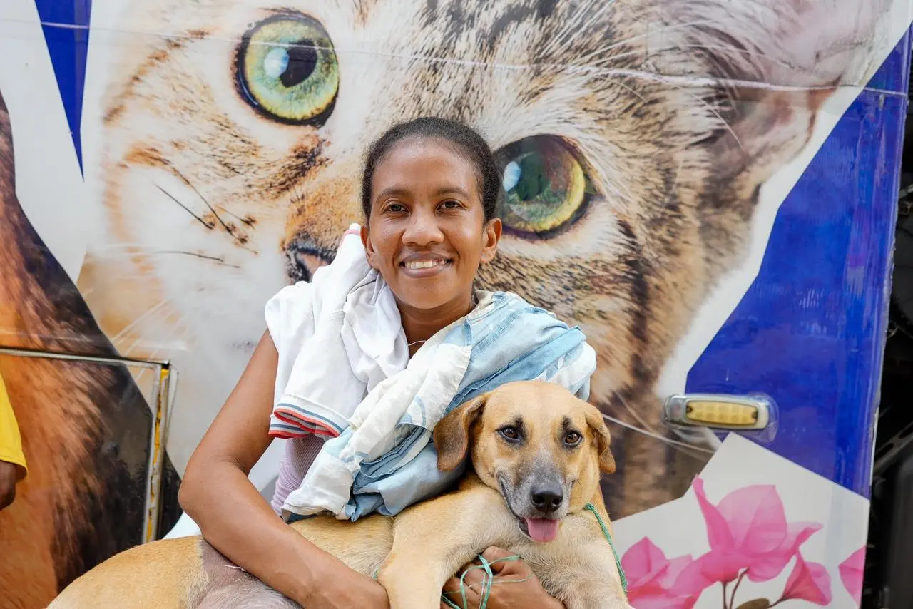 Mujer sonríe junto a un perro durante la jornada de atención integral