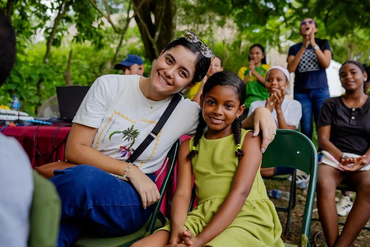 Mujer abraza a una niña durante una actividad comunitaria