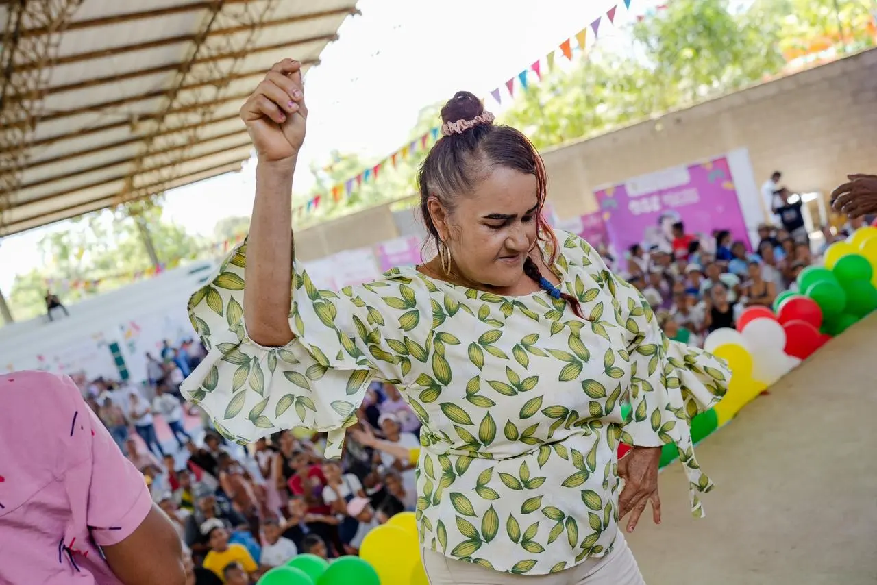 Mujer participa en una actividad cultural frente a la comunidad