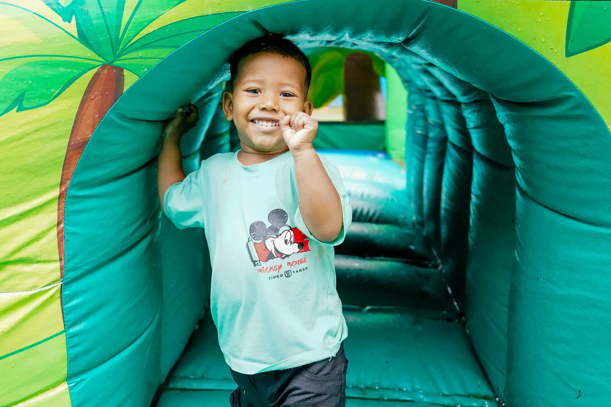 Niño sonríe dentro de un juego inflable