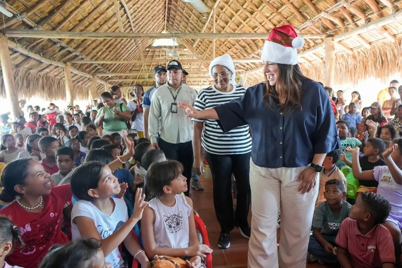 Personajes navideños saludan a niñas y niños en una actividad comunitaria