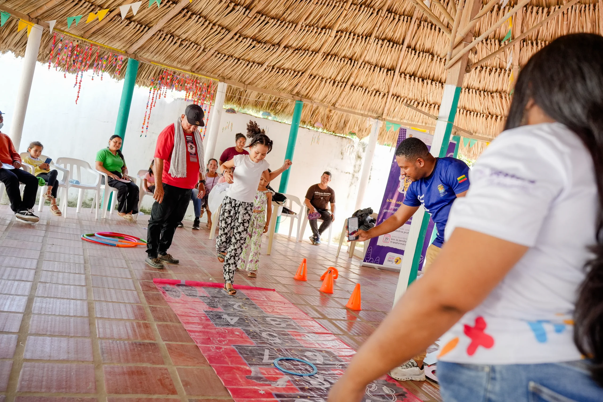 Participantes realizan una actividad motriz con aros y conos