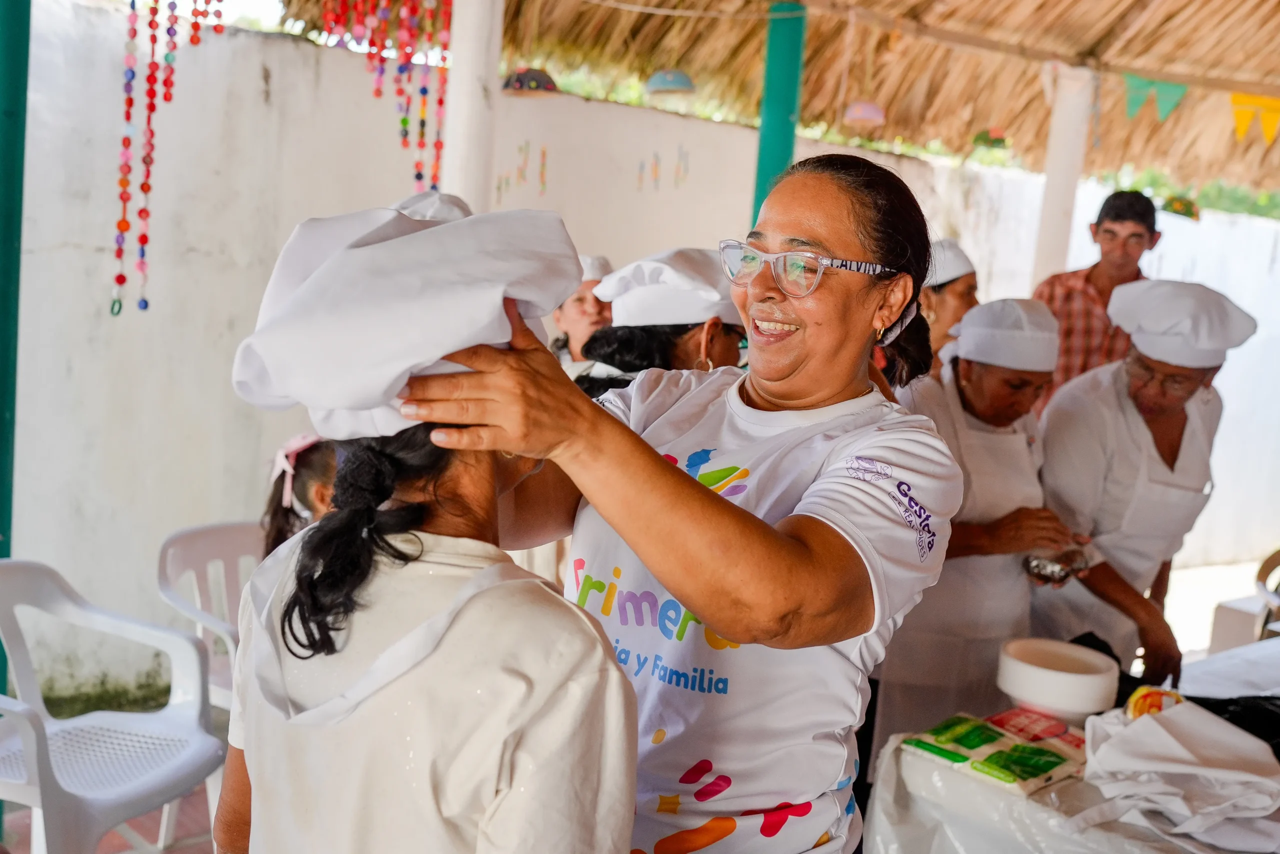 Facilitadora coloca un gorro de cocina a una participante