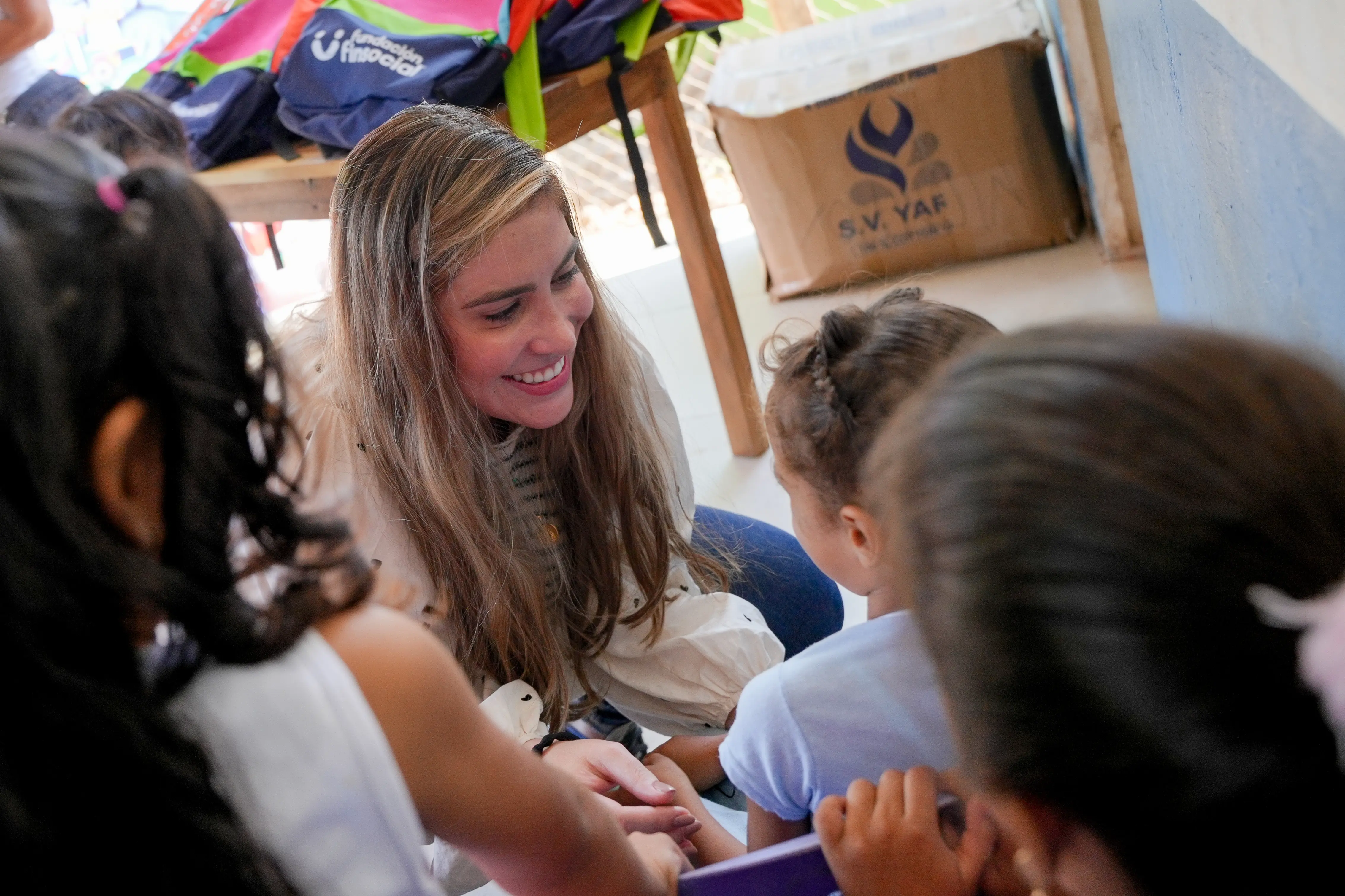 Gestora social saluda a estudiantes en una comunidad educativa