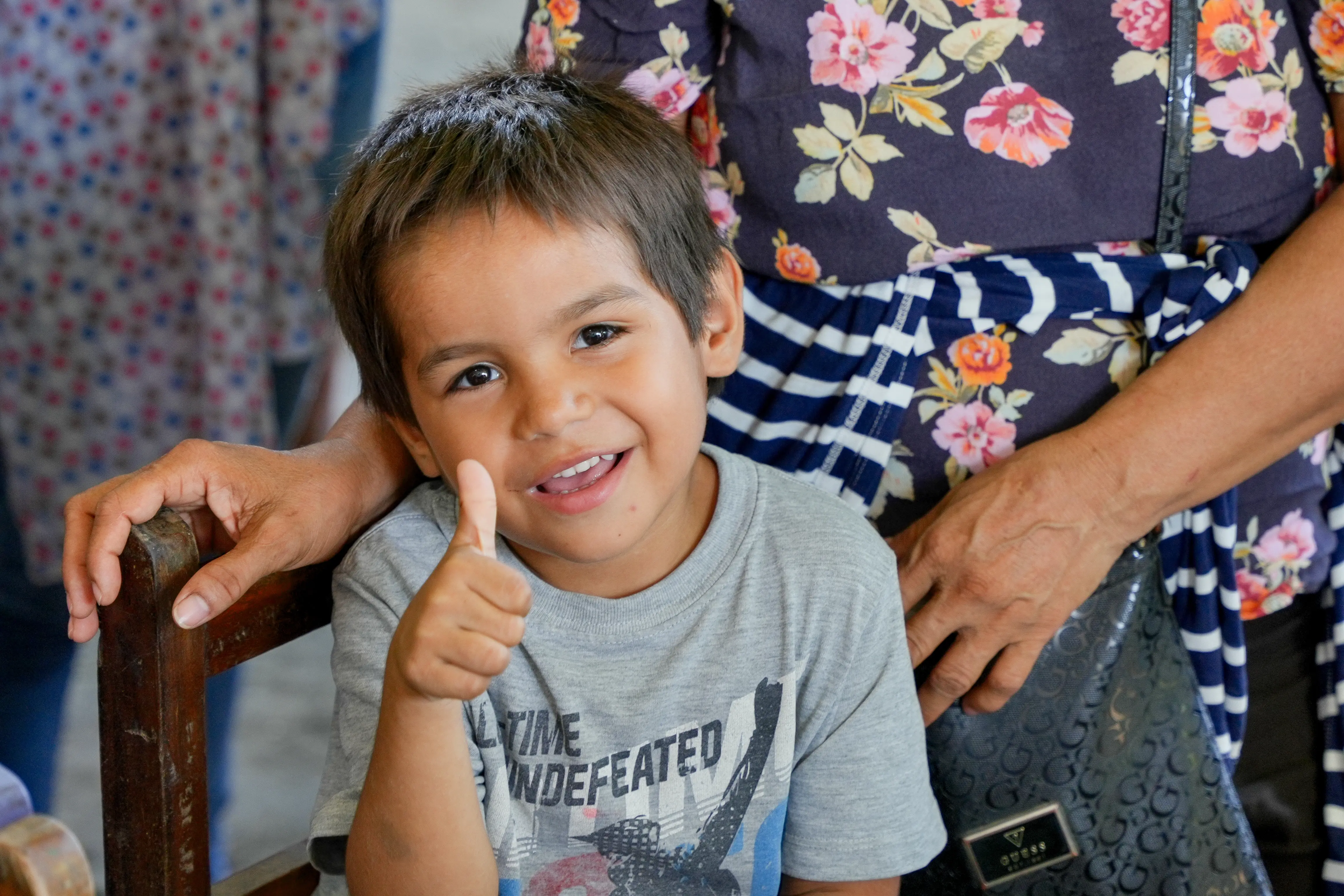 Niño sonríe y levanta el pulgar durante la jornada escolar