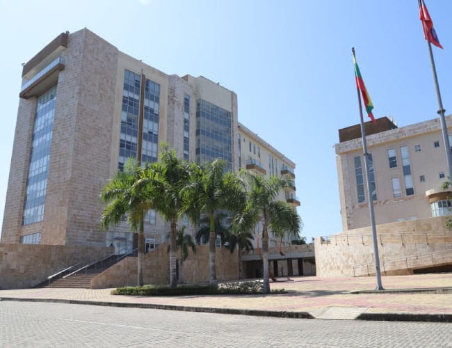 Edificio de la Gobernación de Bolívar con palmeras, banderas institucionales y fachada moderna.