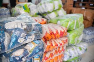 Paquetes de alimentos y víveres apilados para la campaña de ayuda humanitaria.