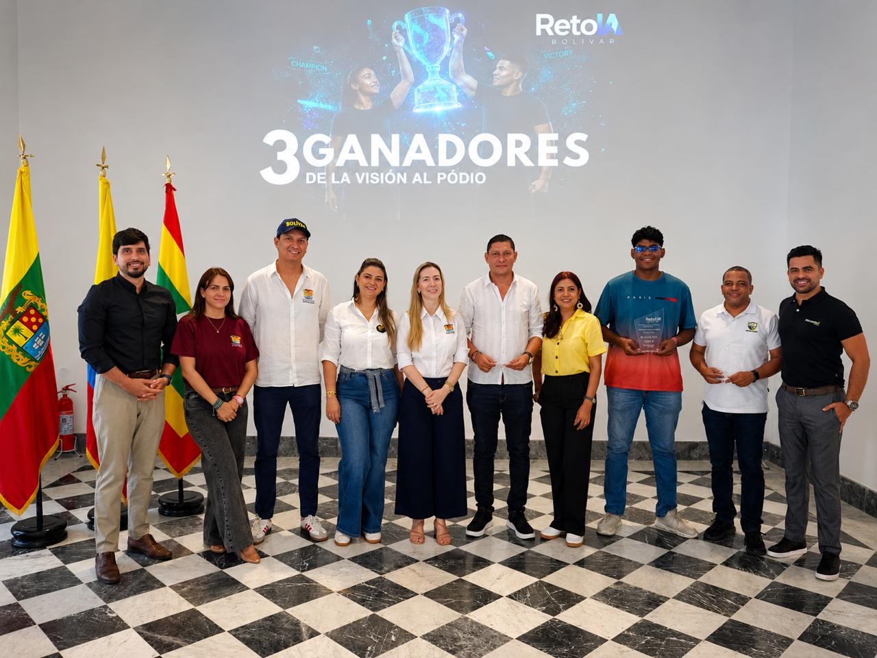 Grupo de personas posa frente a una pantalla que anuncia los tres ganadores del reto.