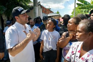 Hombre con gorra de Bolívar conversa con un grupo de habitantes de la comunidad.
