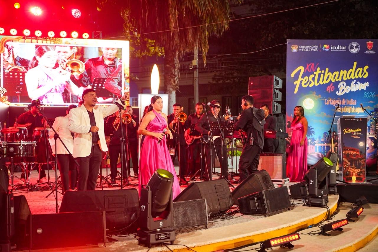 Músicos y cantantes en tarima iluminada durante el Festival de Bandas de Bolívar.