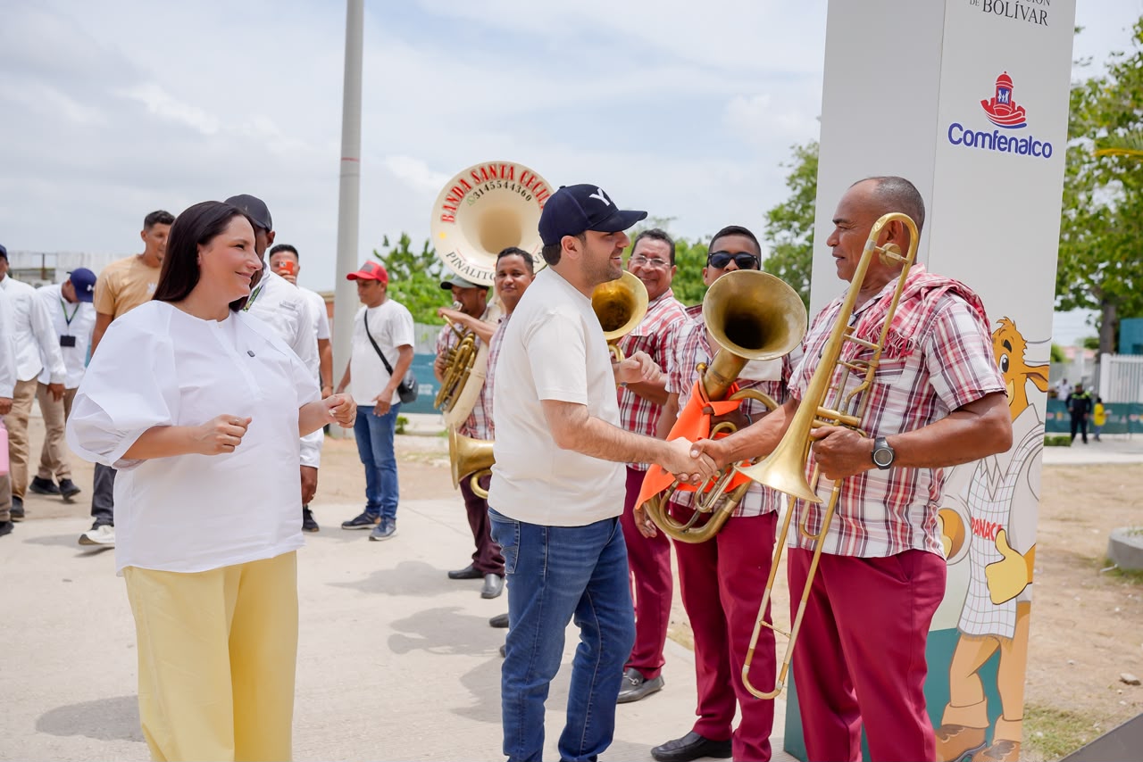 Músicos de una banda con instrumentos de viento saludan a los visitantes en Panaca Viajero.