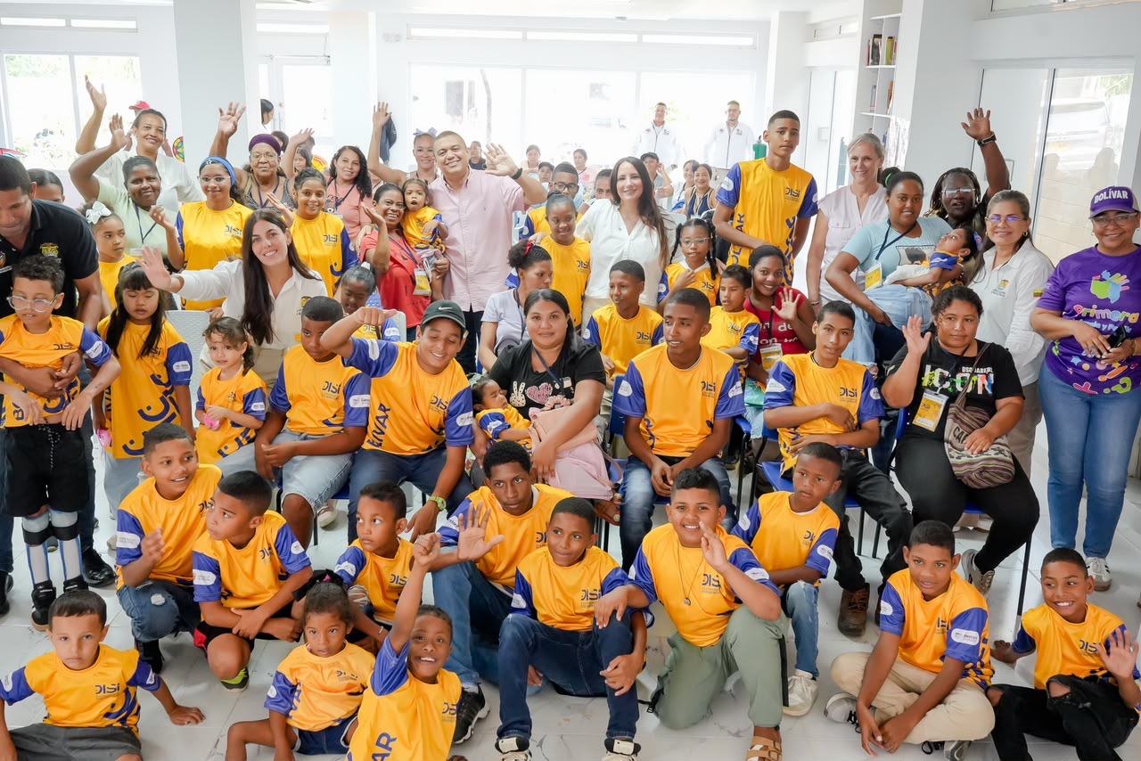 Niños, niñas y adultos con camisetas amarillas celebran durante el lanzamiento del programa.
