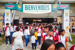 Estudiantes y familias entran a Panaca Viajero bajo un arco con el letrero Bienvenidos.